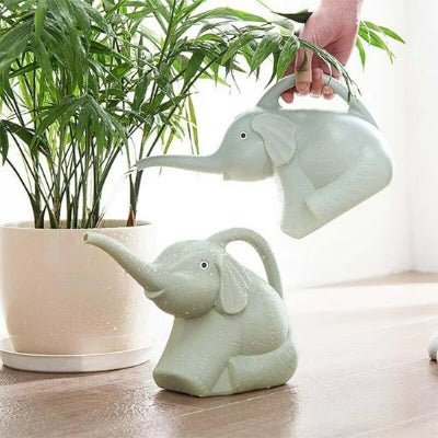 deux modèles de l'Arrosoir plastique Elephant-Eau vert près d'une plante d'intérieur