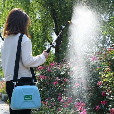 FEmme arrosant ses fleurs roses avec le Pulvérisateur Eletrique Jardin Multrifonction à l'extérieur