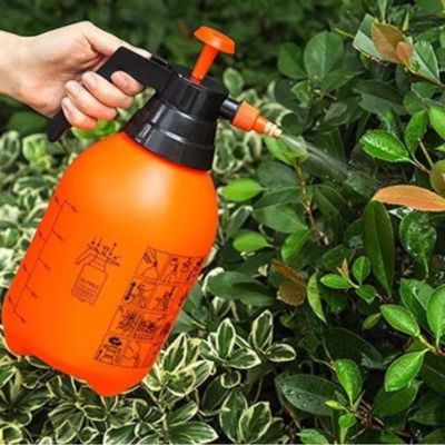 Pulvérisateur jardin Aquapulse duo orange  en action dans la haie d'arbustes