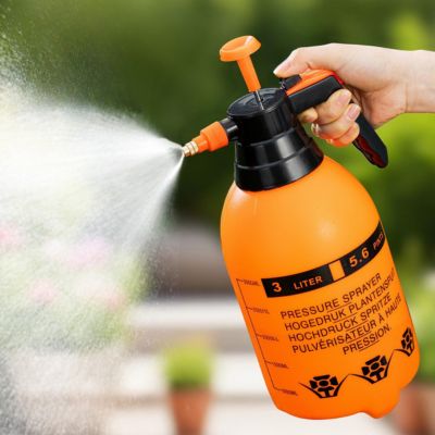 Pulvérisateur jardin Aquapulse duo orange  en action à l'extérieur