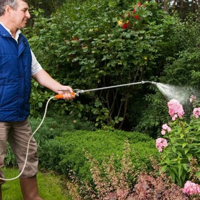 Senior arrosant se fleurs avec le Pulvérisateur Professionnel Réglable FlowMaster