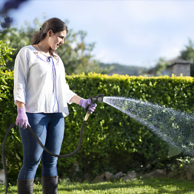 Tuyau arrosage extensible FlexStream Pro dans mains jardinire gants violet