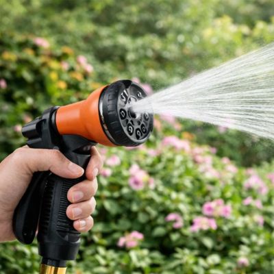 Personne arrosant des fleurs avec le tuyau d’arrosage extensible UltraFlex  et son pistolet orange.